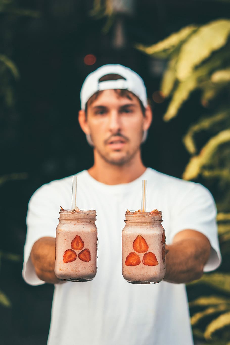 selective focus photography of man holding two mason jars filled with beverage, selective focus photography of two smoothies HD wallpaper
