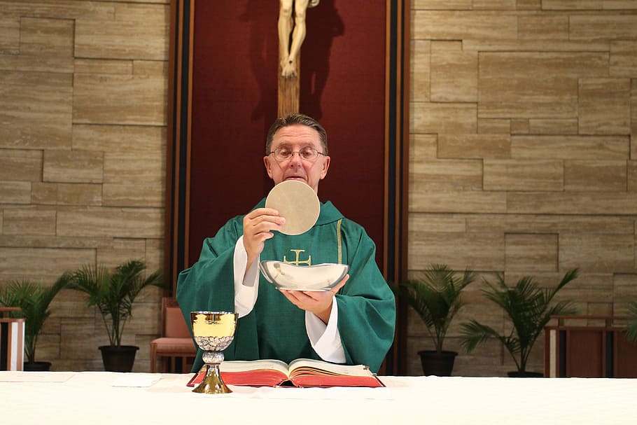 priest holding ostia and bowl during on altar, Consecration, Catholic, Mass