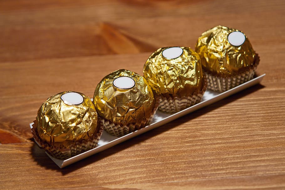 four chocolates on wooden surface, food, sweet, gold, dessert HD wallpaper