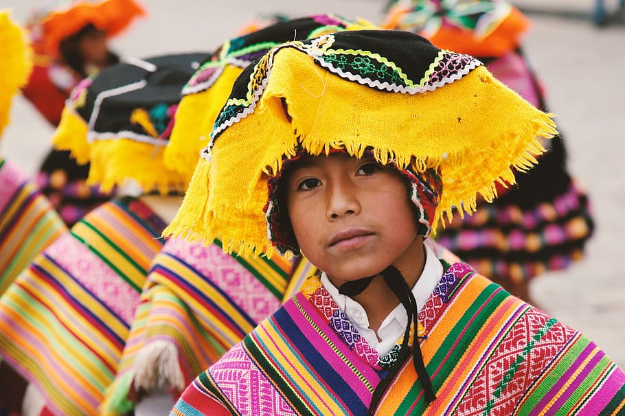 boy in traditional costume in shallow focus photography, boy wearing multicolored traditional suit