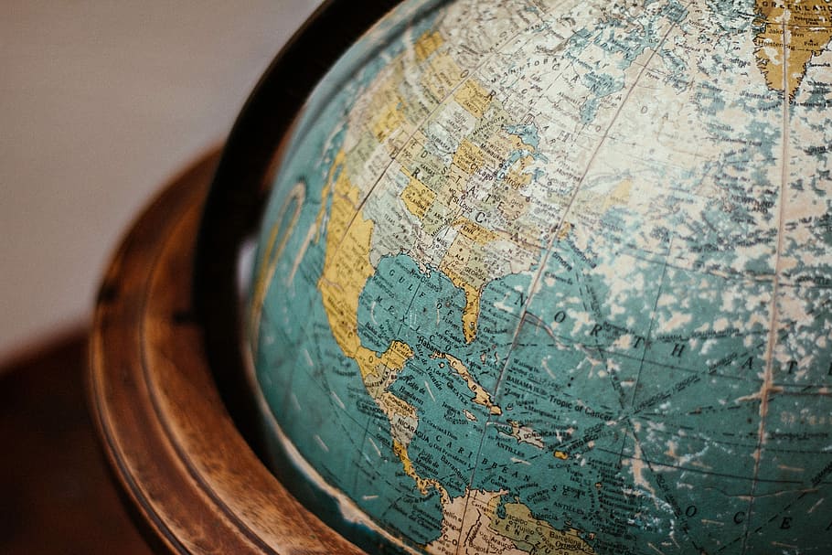 blue earth globe on table, shallow focus photography of blue and brown desk globe HD wallpaper