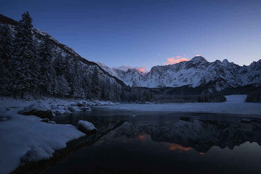 body of water near mountain at dawn, landscape photography of mountains covered with snow HD wallpaper