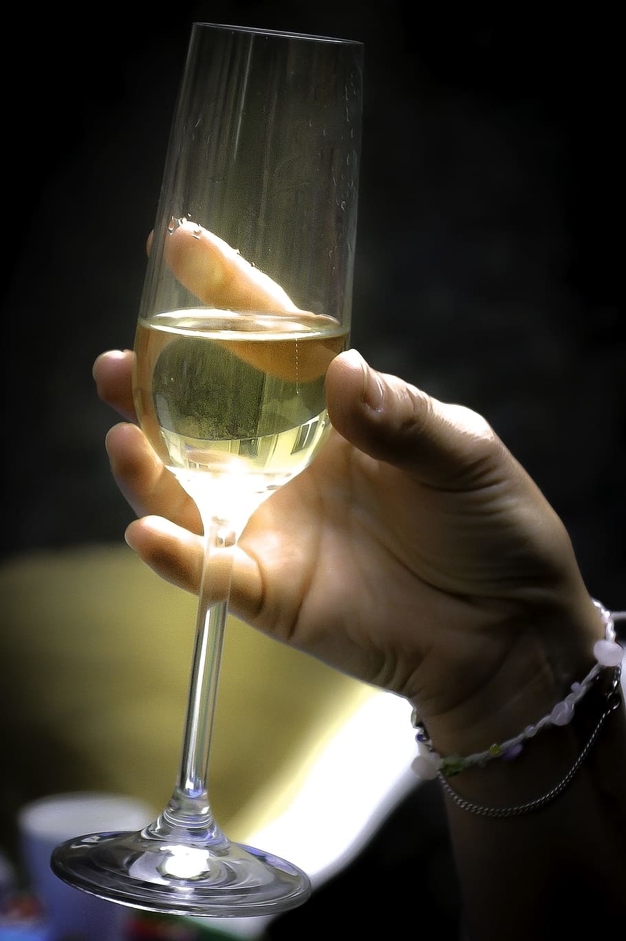person holding clear flute champagne glass filled with yellow liquid HD wallpaper