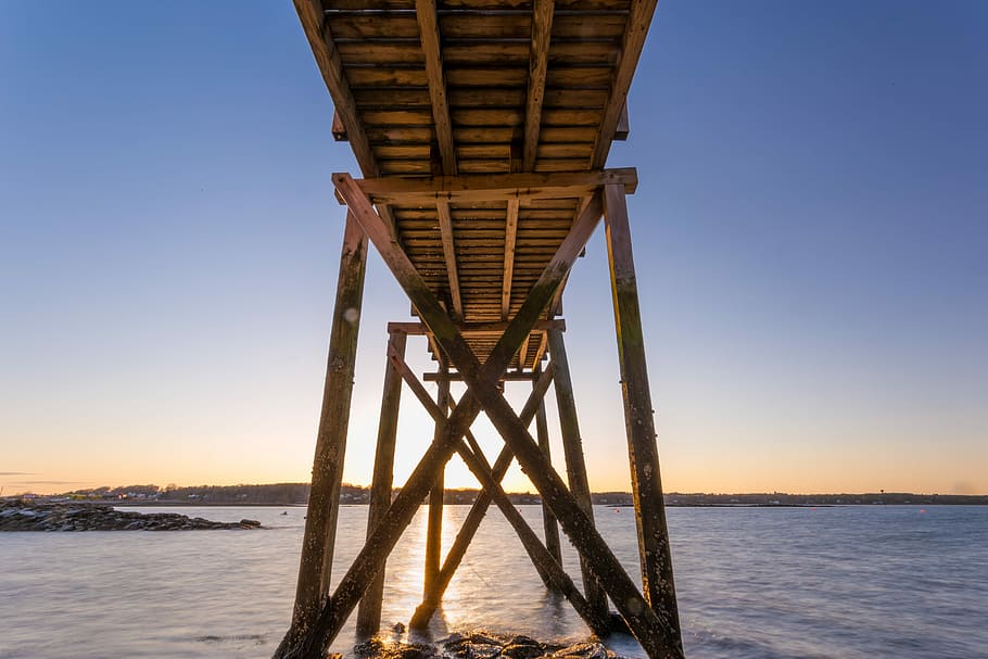 brown wooden dock in low angle shot, brown wooden dock on body of water under blue sky HD wallpaper