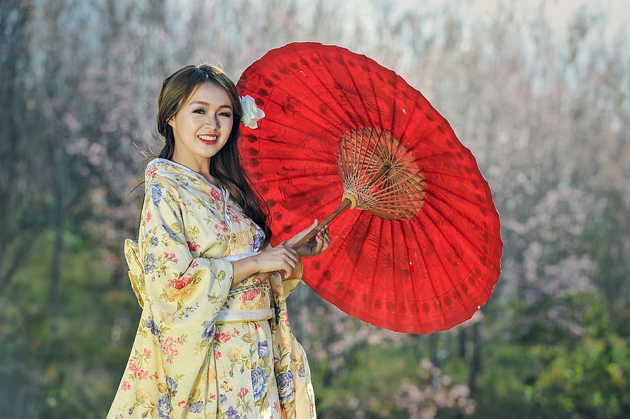 woman in beige floral dress holding oil paper umbrella, beauty