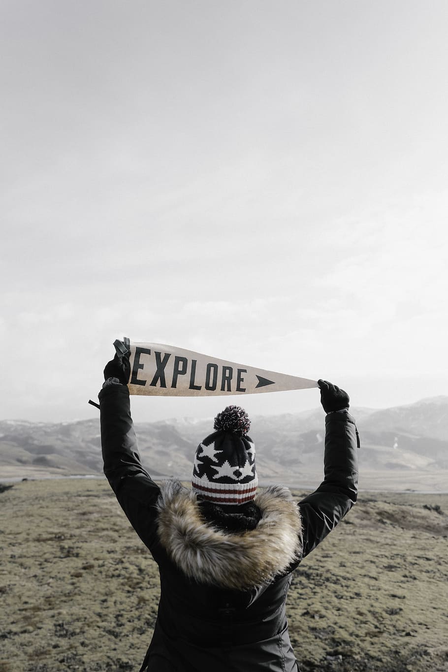 photo of person in black jacket holding Explore banner, woman in black and white bottle hat holding pennant HD wallpaper