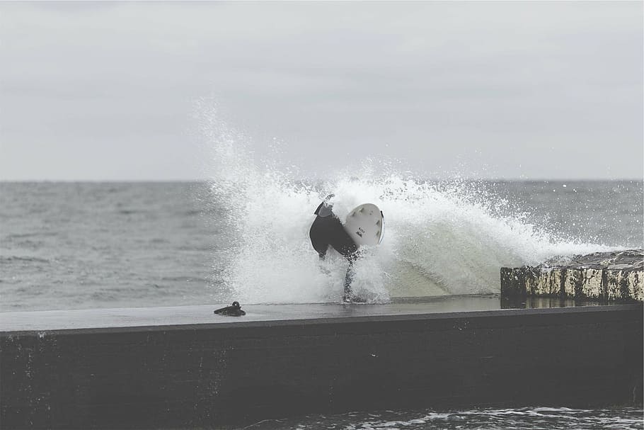 body of water splashing of person while holding surfboard, grayscale HD wallpaper