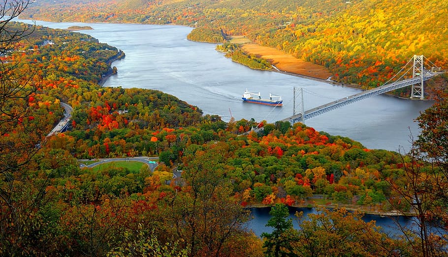 aerial photo of bridge and boat between island, blue and brown ship on body of water beside tension bridge HD wallpaper