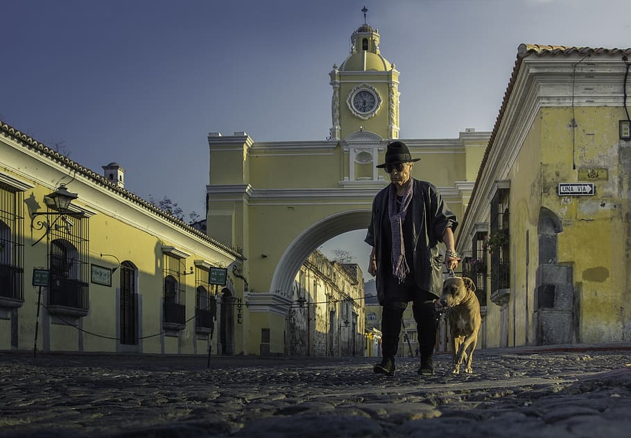 man and dog beside building during daytime, antiguaguatemala