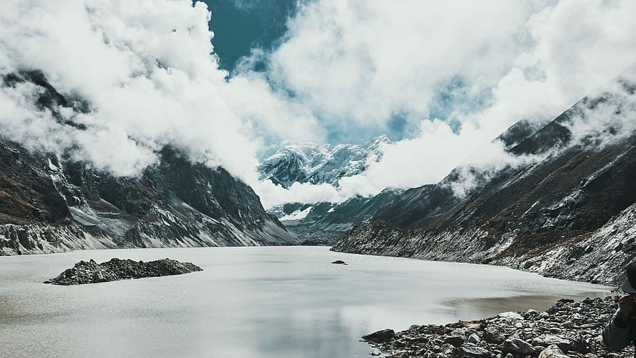 body of water surrounded by mountain range, gray mountain cover by snow during daytime HD wallpaper