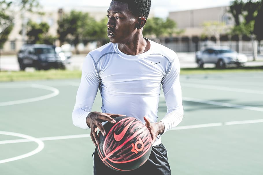 selective focus photography of person on Nike sweatshirt and holding black basketball, HD wallpaper