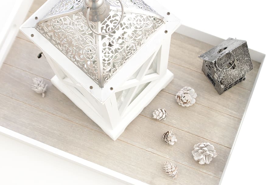 conifer cones beside white candle lantern on wooden deck, live HD wallpaper