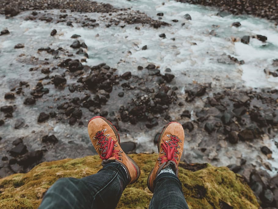 person wearing pair of brown suede work boots, person sitting down on rock formation HD wallpaper