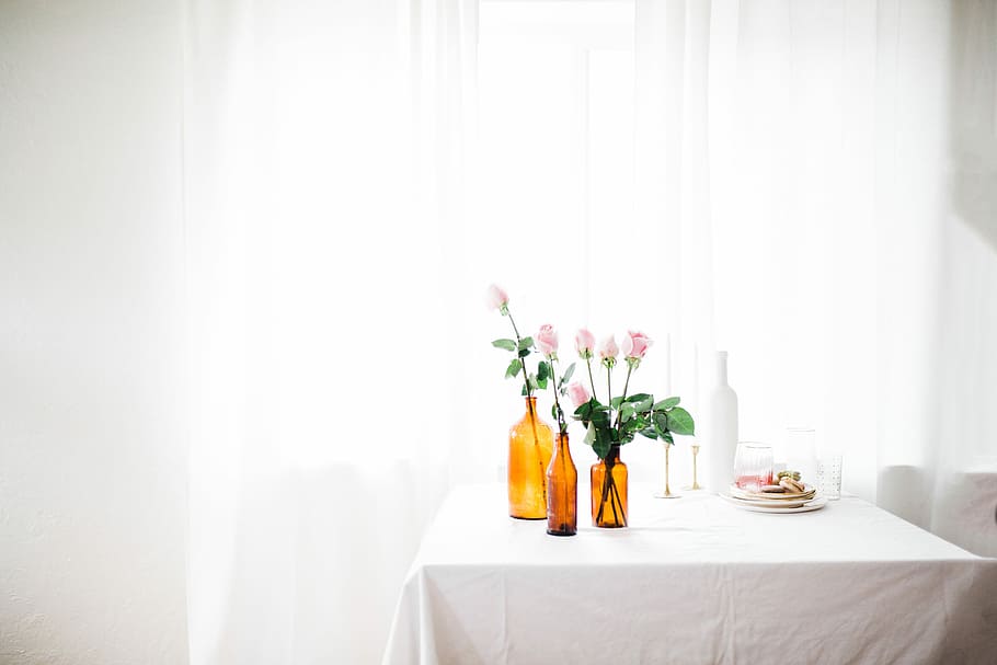 three amber glass flower vase with pink flowers on white table near window curtain, pink flowers on table HD wallpaper