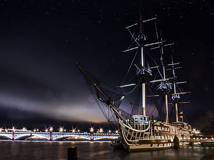 galleon ship sailing on body of water near bridge under stars nighttime HD wallpaper