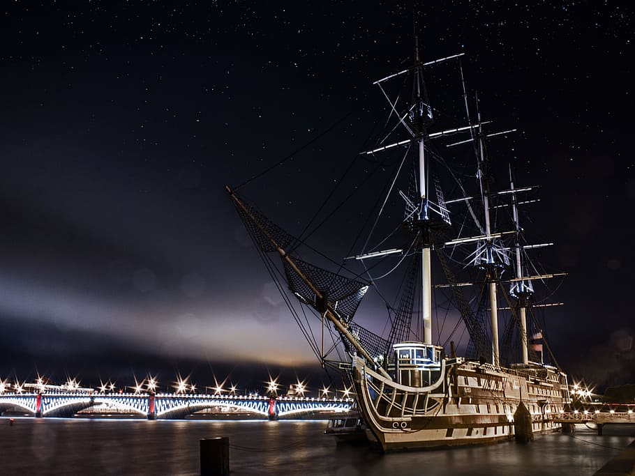 galleon ship sailing on body of water near bridge under stars nighttime HD wallpaper