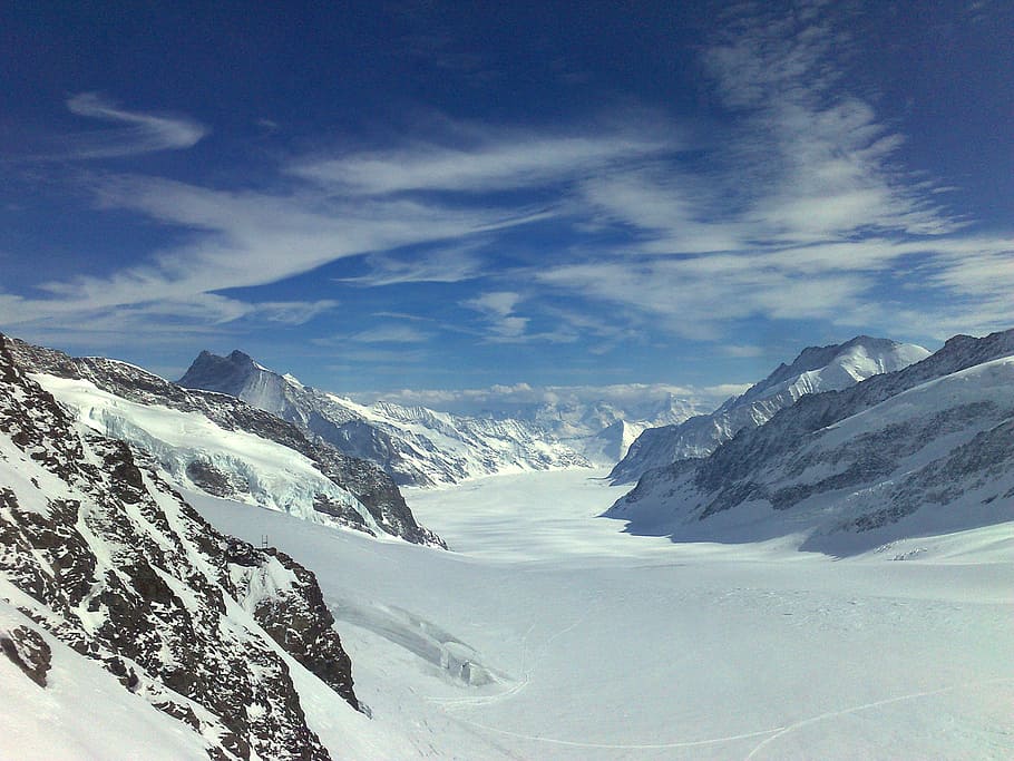 white cirrus clouds over snow covered mountain, aletsch glacier the konkordiaplatz