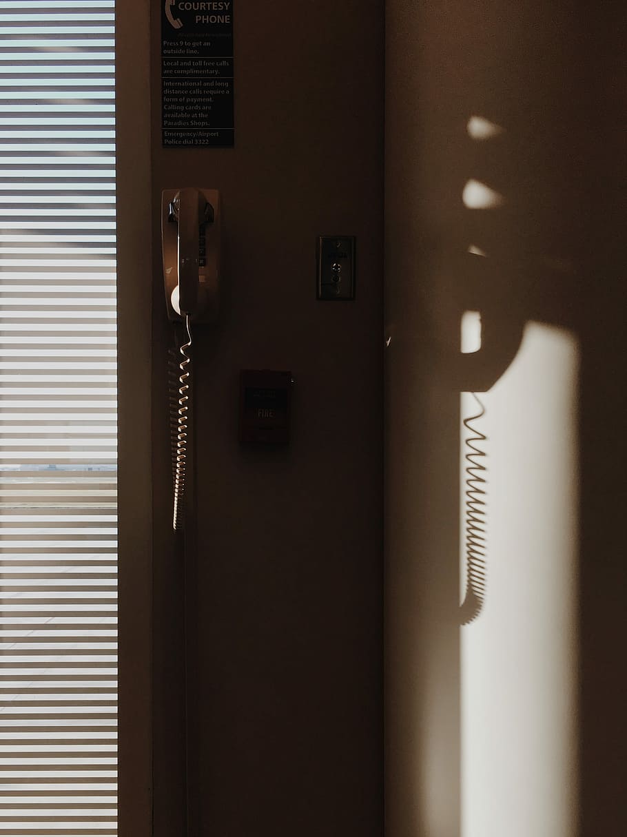 white corded telephone mounted on wall near window with window blinds, telephone mounted on white wall HD wallpaper