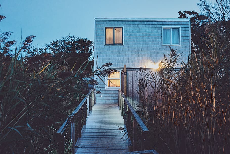 white painted house with turned on light, photography of gray concrete house in front of bridge HD wallpaper