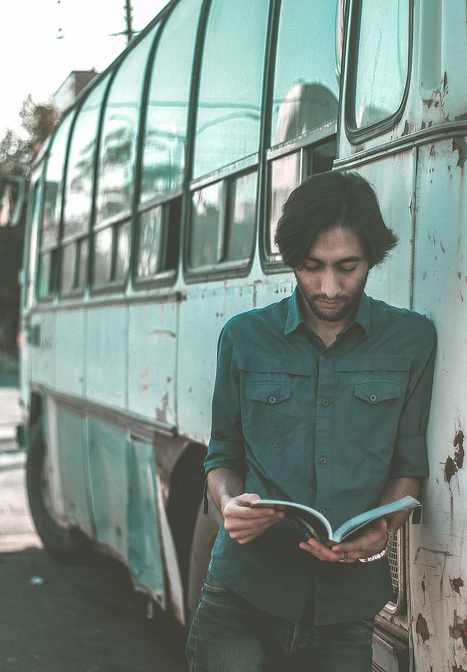 man reading book while leaning on buss, male, beard, rusty HD wallpaper