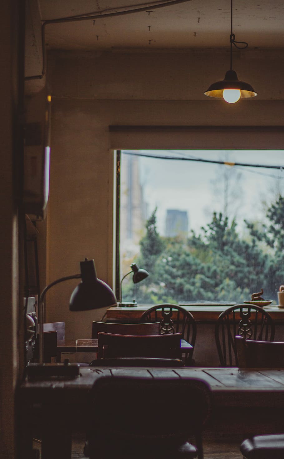 dining tables, black task lamp on tabletop, chair, cafe, window