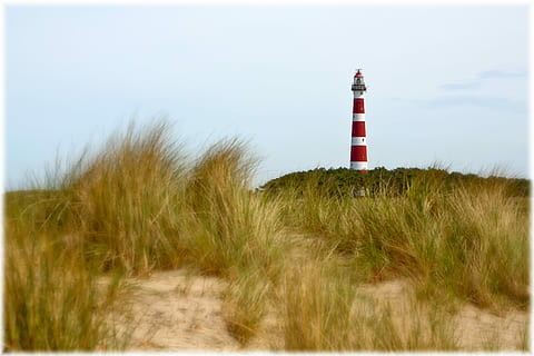 photography of white and red light house under cloudy sky during daytime HD wallpaper
