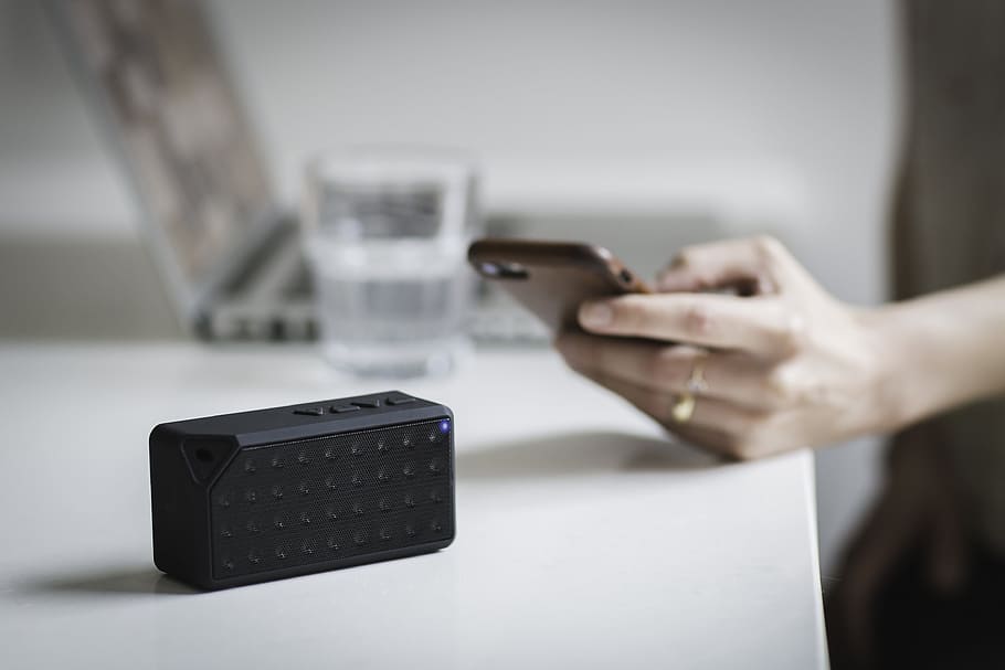black Bluetooth speaker on white table, people, blur, laptop HD wallpaper