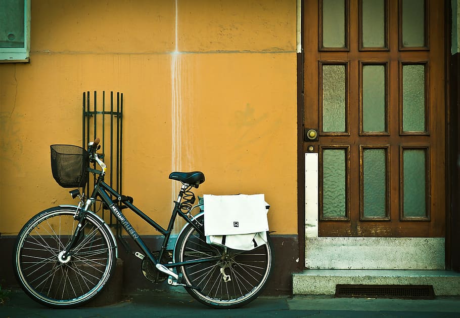 bicycle parked beside orange wall and door, facade, bike, front door
