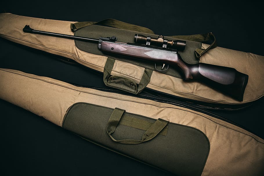 brown and black sniper rifle with beige bag, brown hunting rifle with scope on brown soft case