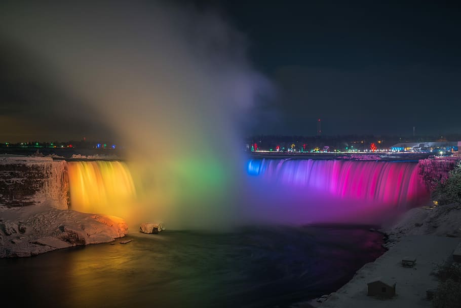 Niagara Falls with lights and overlooking view of buildings during nighttime, photo of waterfalls at nighttime