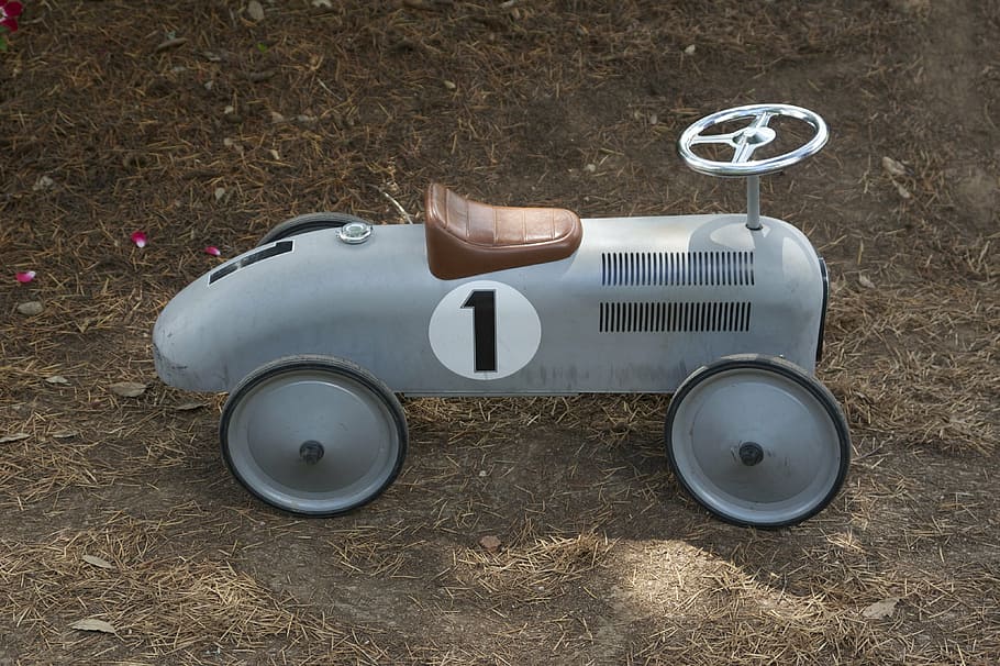 white and black ride-on car on brown soil, gray, toy, grey, child