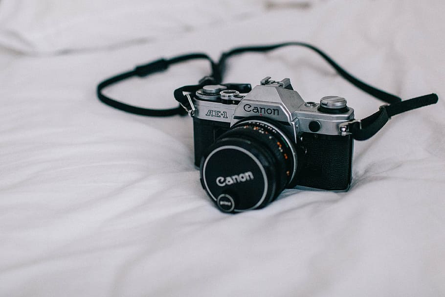 black Canon DSLR camera on the white textile, photography, film
