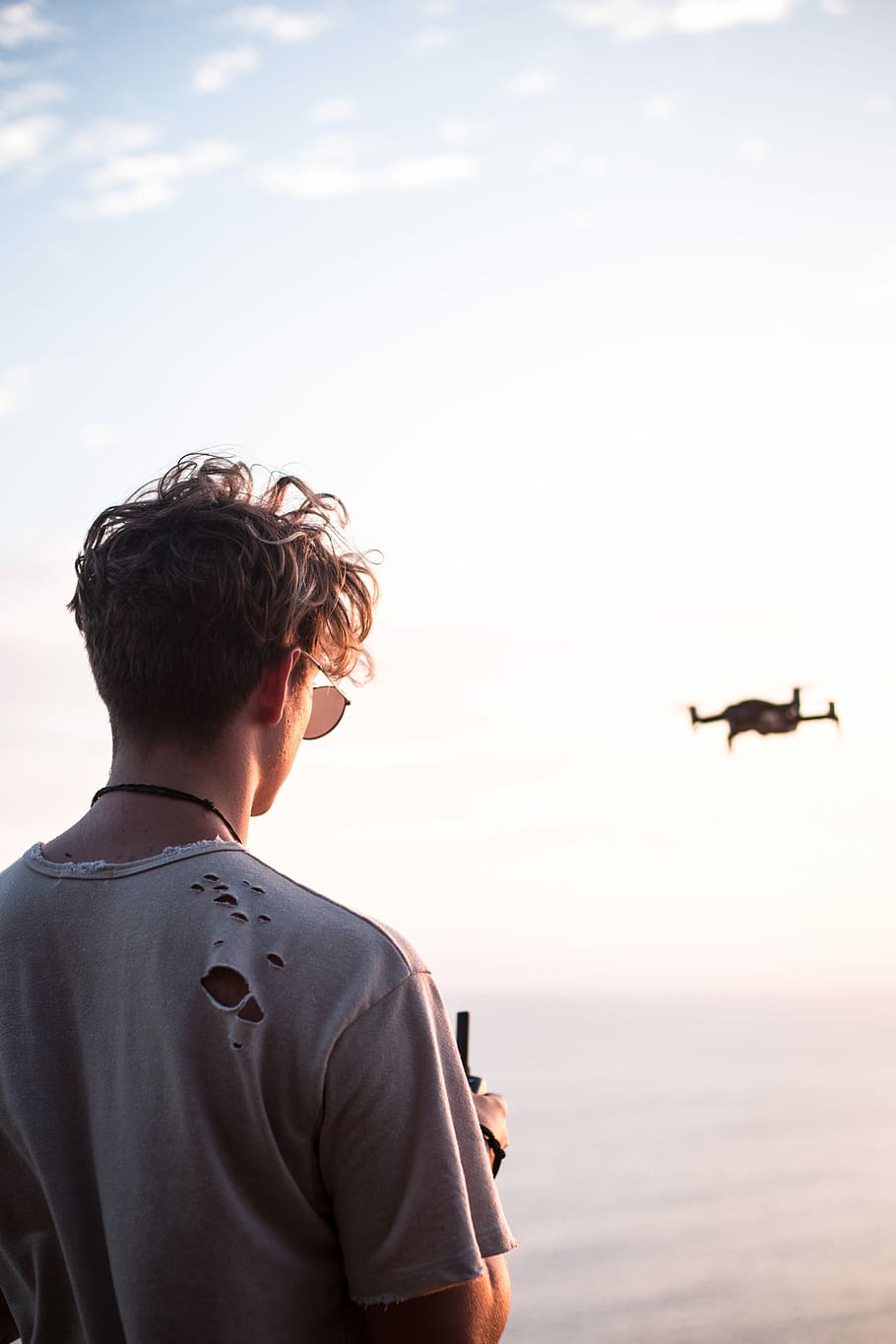 man controlling drone at daytime, head, flying, tshirt, hole HD wallpaper