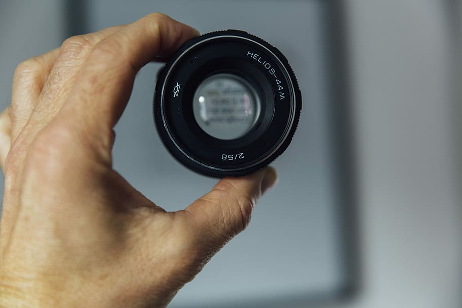 person holding camera lens, person holding black lens, lense HD wallpaper