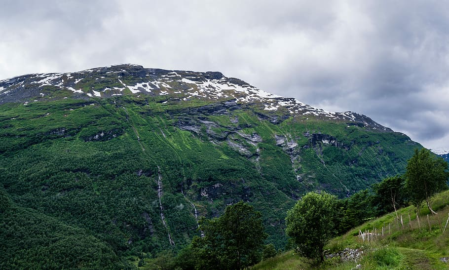 green plant covered mountain with ice caps under cloudy skies, landscape photography of mountain HD wallpaper