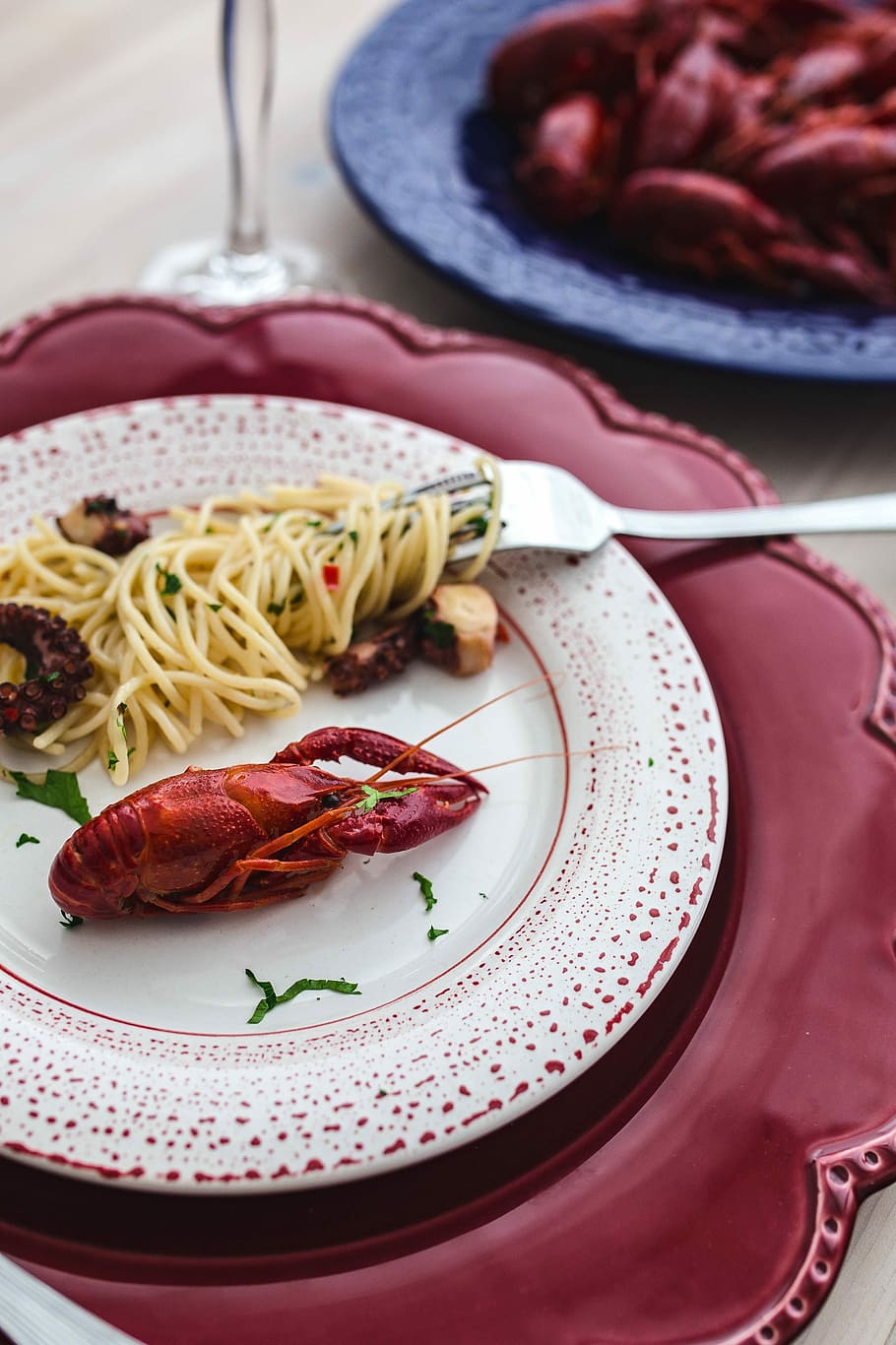 Fancy dinner with seafood pasta, crayfish and red wine by the table decorated with roses HD wallpaper