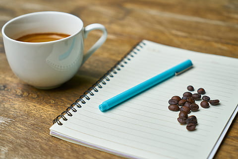 teal ball-point pen on white notebook beside coffee bean, cup HD wallpaper