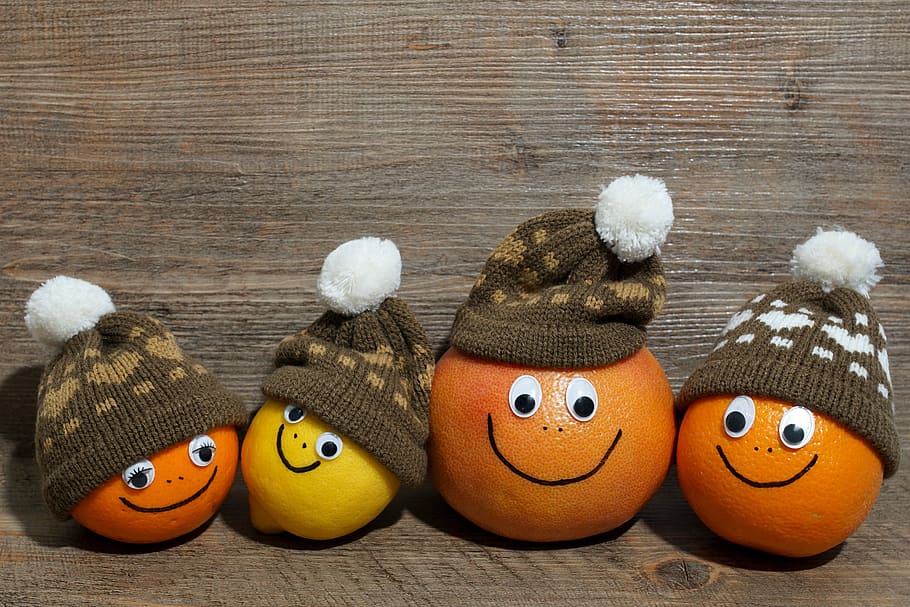 three orange fruits and one yellow citrus with bobble caps, grapefruit