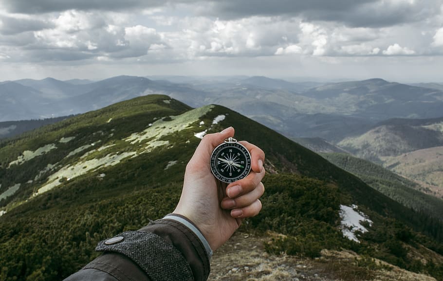 person holding silver compass, person holding compass, Mountains
