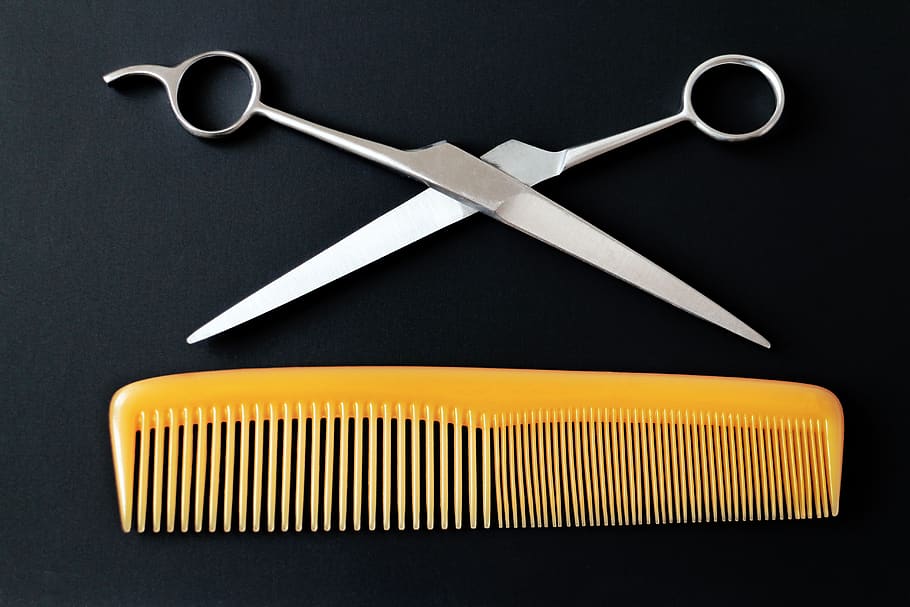 Black hairdresser scissors on wooden background, close up Stock