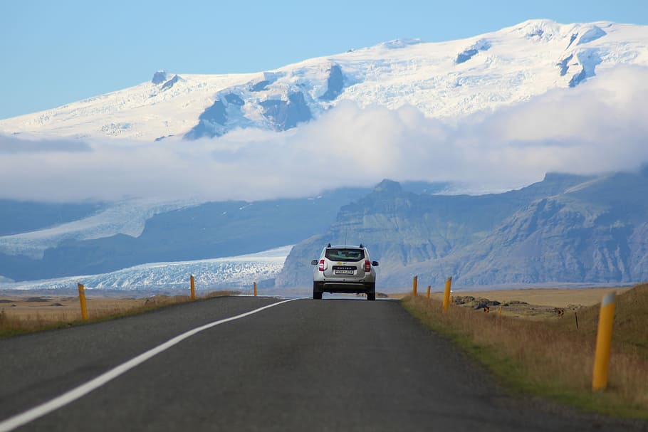 white SUV passing through roadway, silver SUV on road near mountain at daytime HD wallpaper