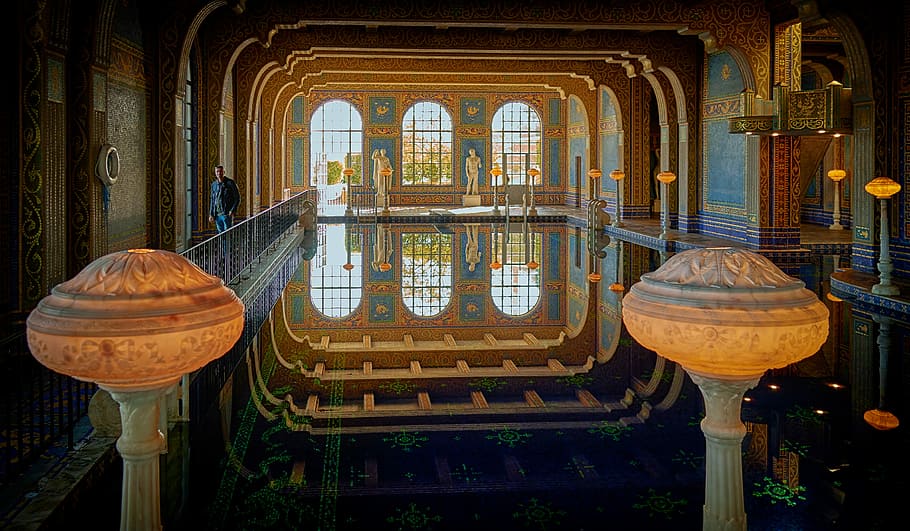 two yellow pillars, photo of person standing near indoor pool HD wallpaper