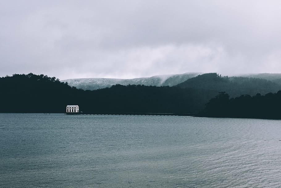 silhouette photo of mountain and body of water during daytime HD wallpaper
