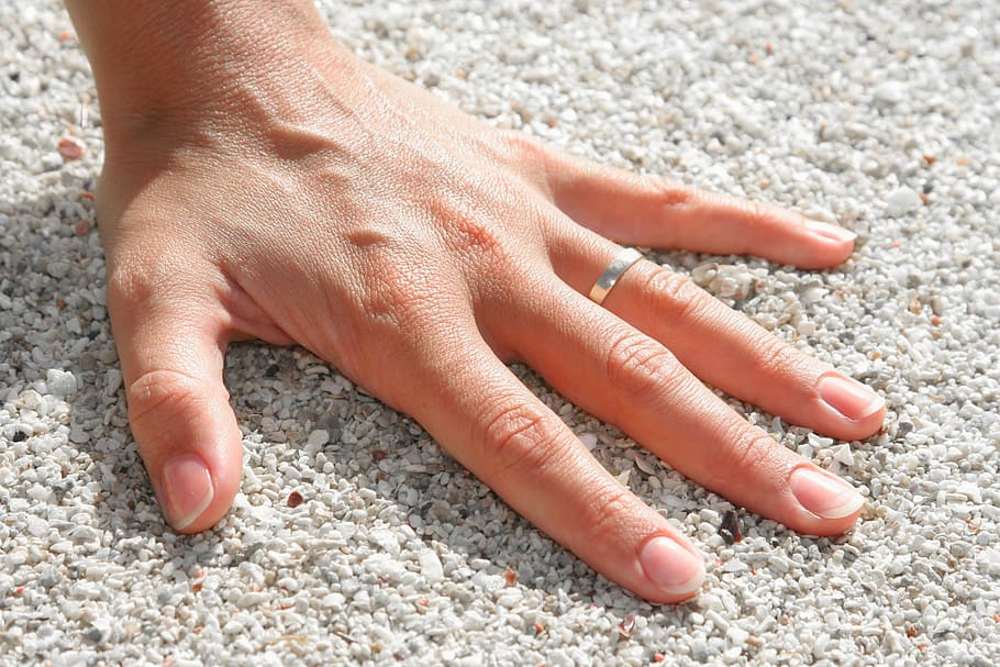 person wearing silver-colored ring, fingers, hand, pebbles HD wallpaper