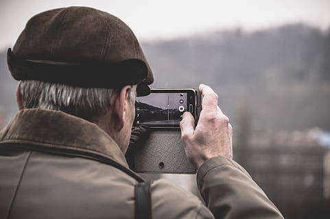 photo of man taking photo using camera, man holding camera taking photo of building at daytime HD wallpaper