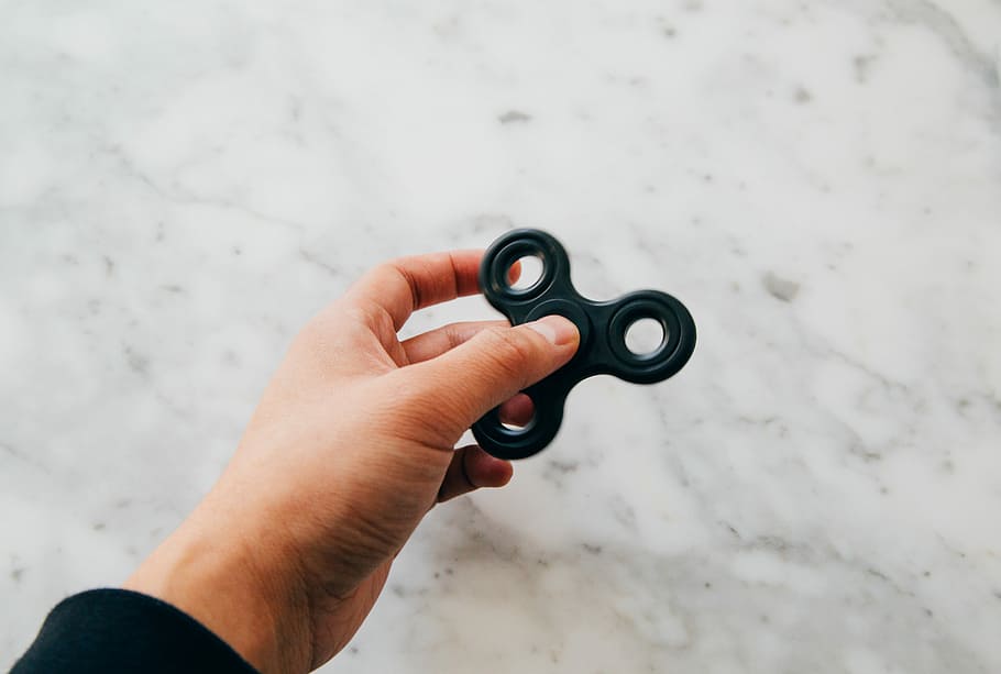 person using black fidget spinner, person holding black hand spinner HD wallpaper