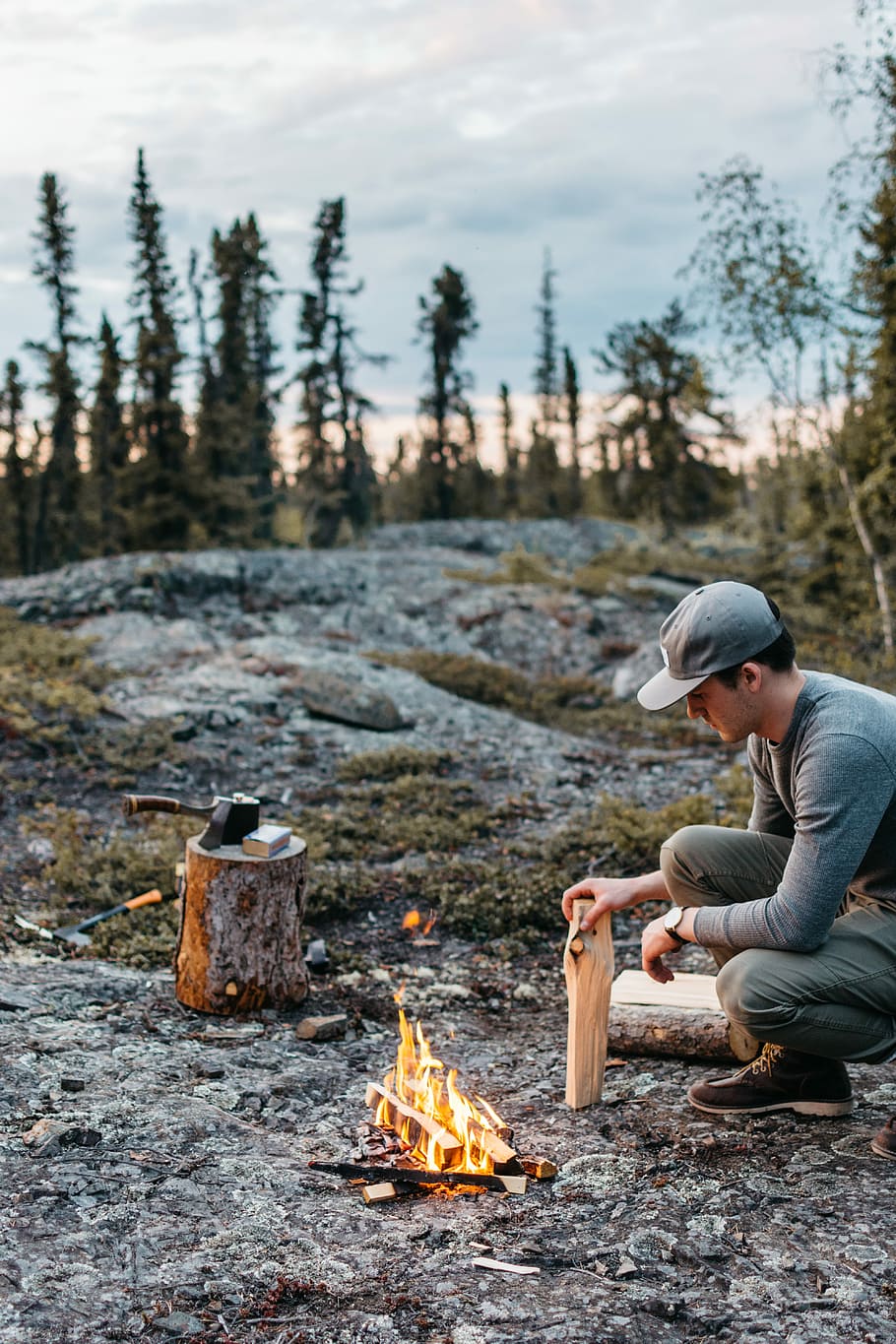 man holding brown wood in front of bonfire, man doing bonfire near top of mountain during daytime HD wallpaper