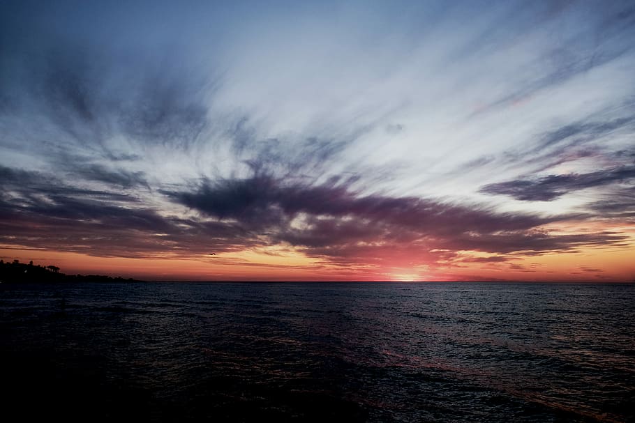 ocean under gloomy sky during golden hour, aerial photography of body of water at sunset HD wallpaper