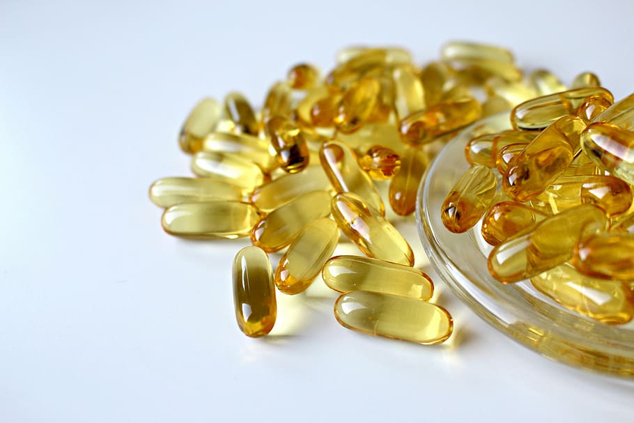 focus photo of capsule lot, fish oil, yellow, oil capsule, glass