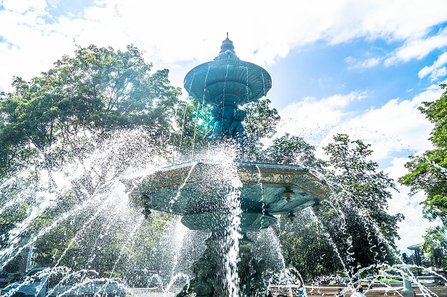shallow focus photo of outdoor fountain under white and blue cloudy sky, teal concrete outdoor fountain HD wallpaper